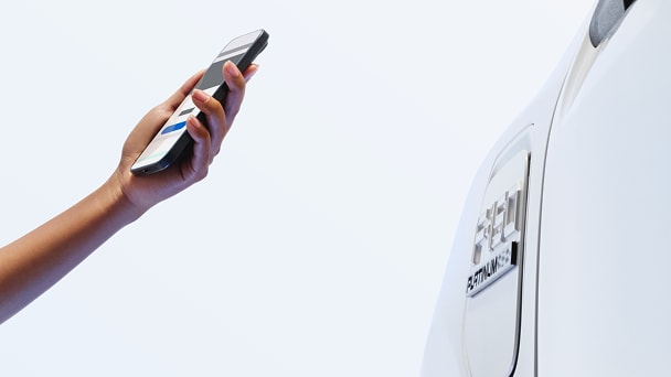 Woman’s hand holding a cellphone and aiming it towards a F-150 Lightning®